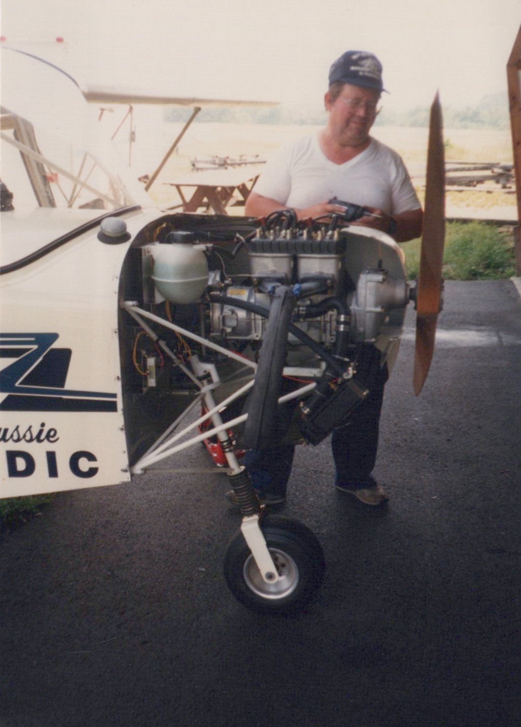 Builder standing beside the uncowled engine installation of a Carlson Sparrow II