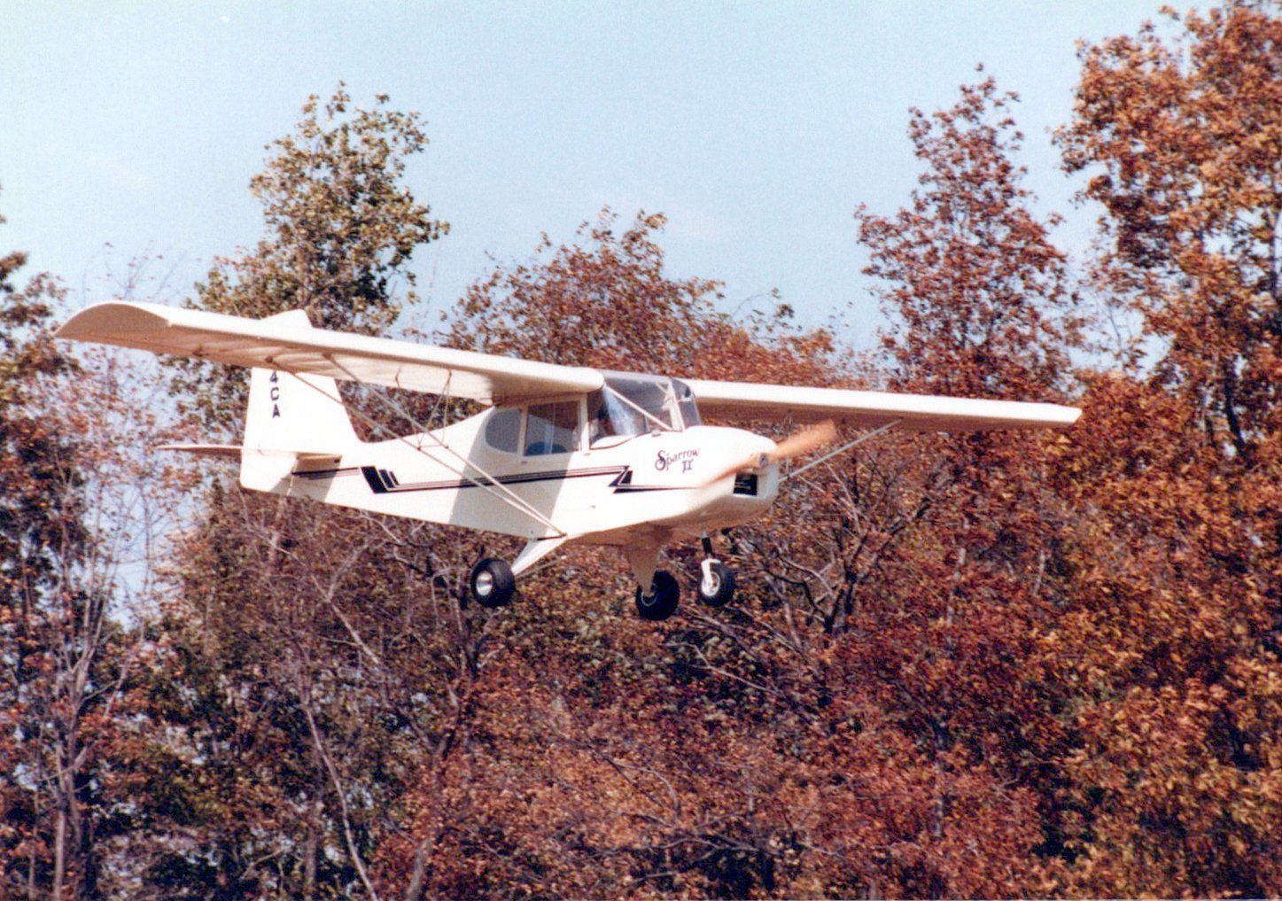 Carlson Sparrow II flying past autumn trees