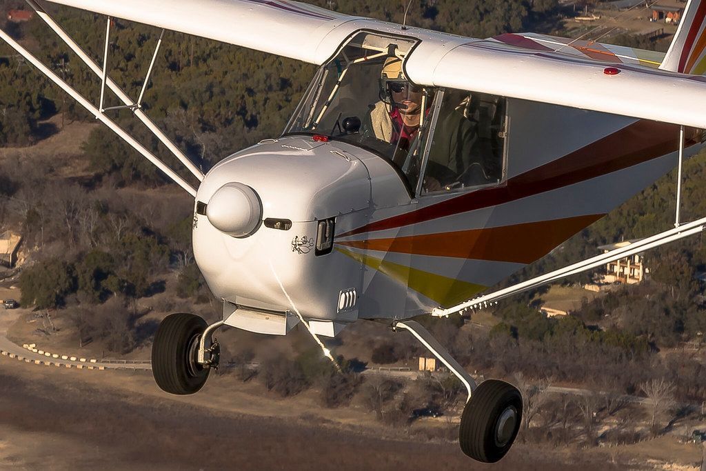 Close air-to-air view of a Carlson Sparrow Sport Special showing the cowling, chin intake scoop and main landing gear