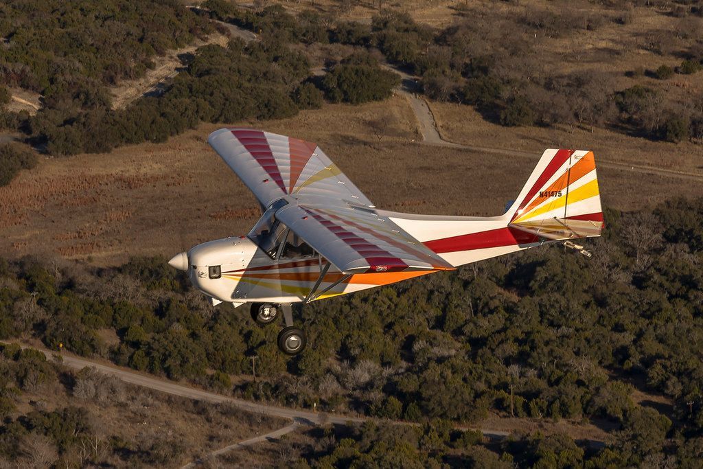 Carlson Sparrow Sport Special N41475 in flight, seen in profile over hill country