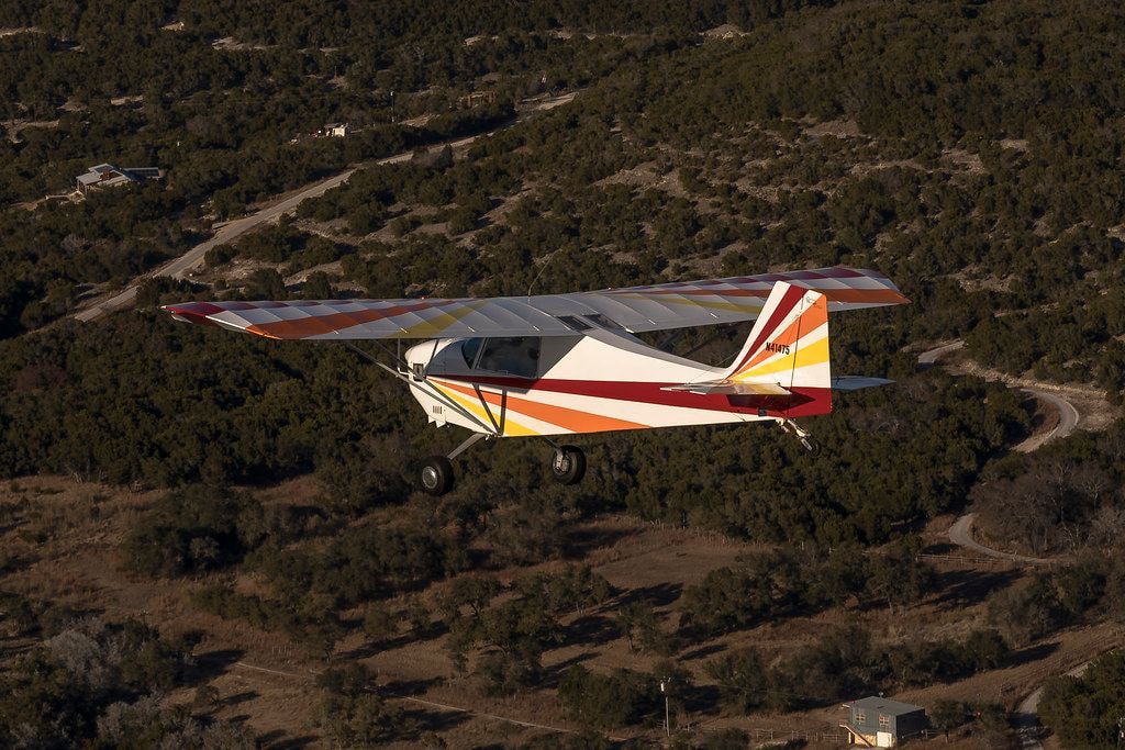 Carlson Sparrow Sport Special flying over wooded hill country